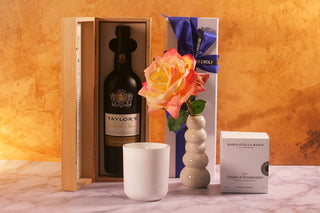 Taylor's Port wine bottle, a candle, a vase with a rose, and a box of Marie-Stella-Maria. Luxury Gift
