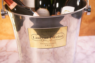Laurent-Perrier champagne bottle in a metal ice bucket with gold label. Champagnegift